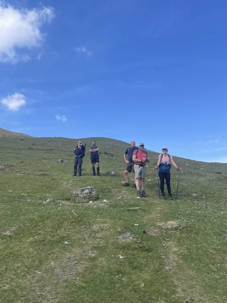 May be an image of 5 people, grass and mountain